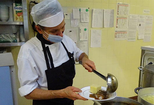 Le cuisinier sert le plat principal