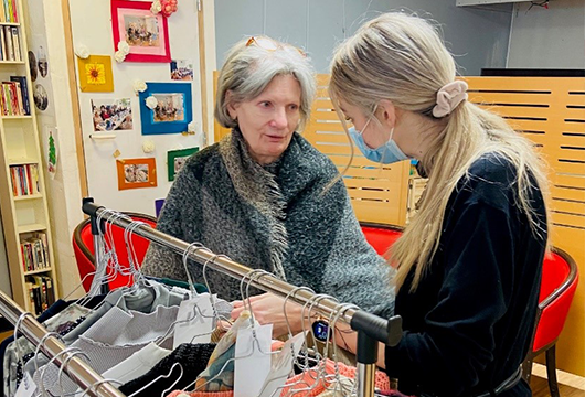 La vendeuse du magasin éphémère conseille une résidente 