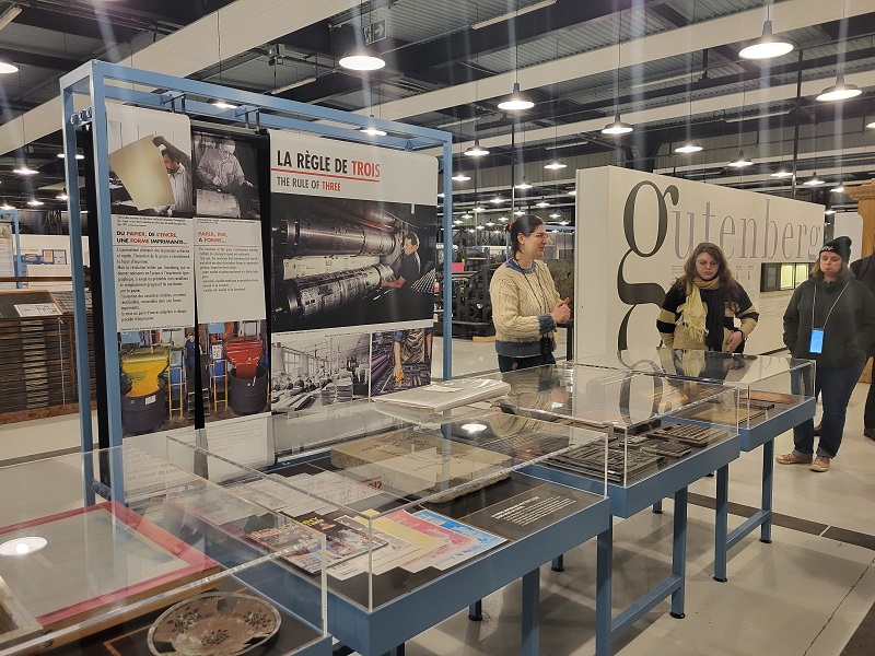un stand avec du matériel d'imprimerie et deux stagiaires