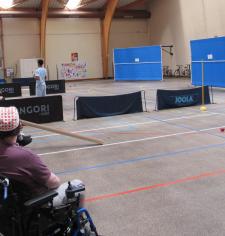 personnes en chaise lançant des balles dans un gymnase