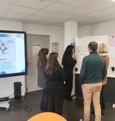 plusieurs personnes en train de travailler autour d'un tableau