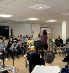 Une quinzaine de personne en train de chanter devant un public